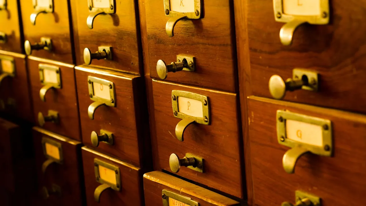 Un meuble à fiches en bois, ses tiroirs et leurs porte-étiquettes en laiton