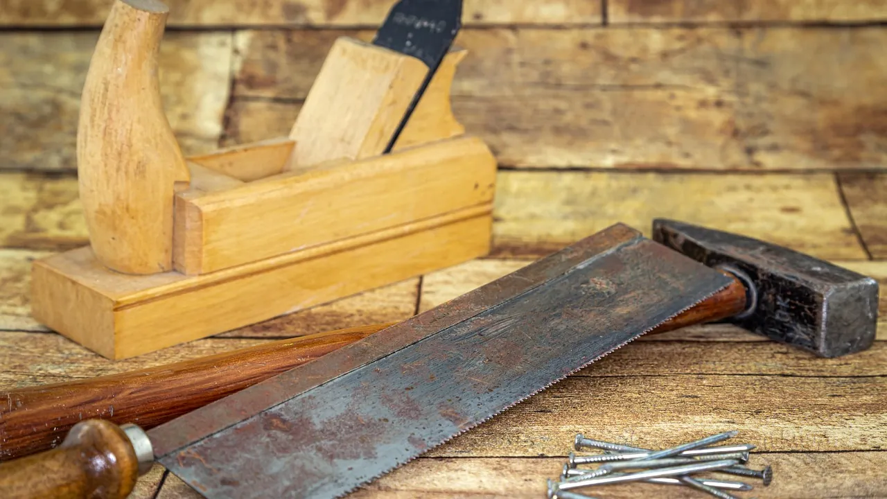 Rabot, scie et marteau sur un établi de bois
